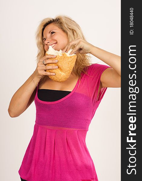 Beautiful brunette girl eating a bread isolated on the white background. Beautiful brunette girl eating a bread isolated on the white background