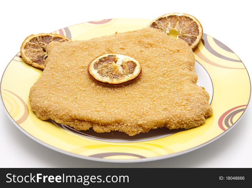 Escalope raw and breaded with lemon onto plates. Escalope raw and breaded with lemon onto plates