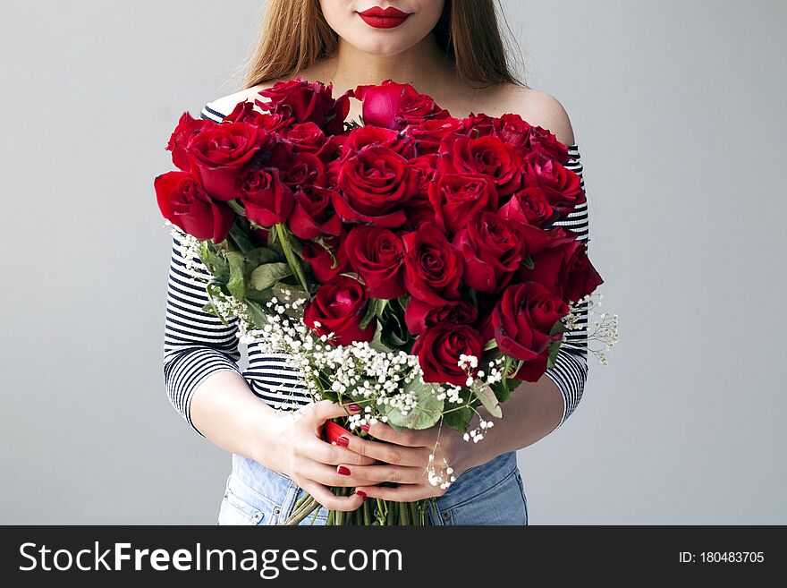 Smiling girl with bouquet of  red roses