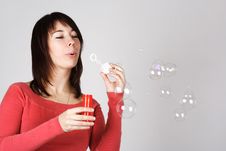 Woman In Red Shirt Blowing Out Soap Bubbles Royalty Free Stock Image