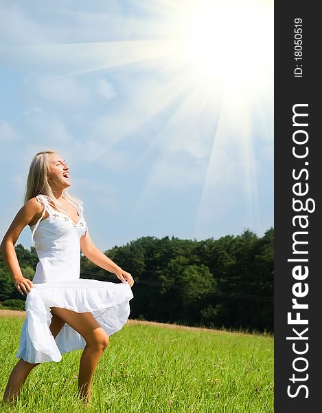Young woman in white dress jumping over green grass. Young woman in white dress jumping over green grass