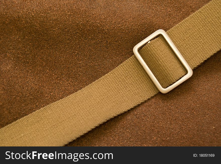 Buckle and thong on a brown pressed leather bag