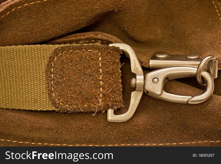 Carbine and thong on a brown pressed leather bag