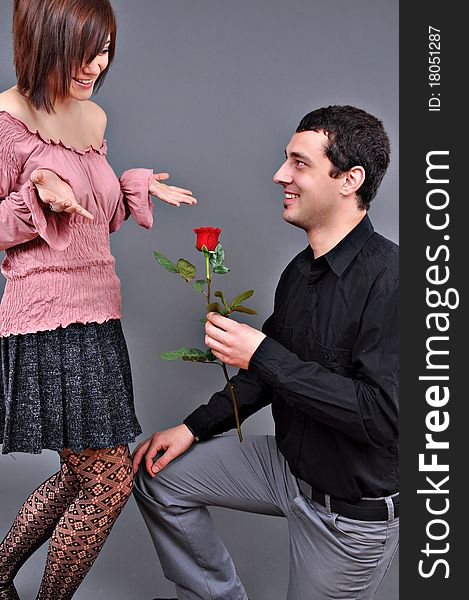 Happy beautiful teenage couple, a boy giving a rose to his girlfriend