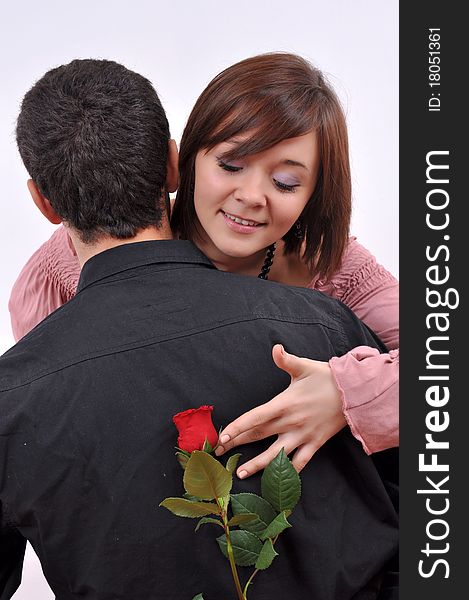 Happy beautiful teenage couple, a boy giving a rose to his girlfriend