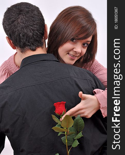 Happy beautiful teenage couple, a boy giving a rose to his girlfriend