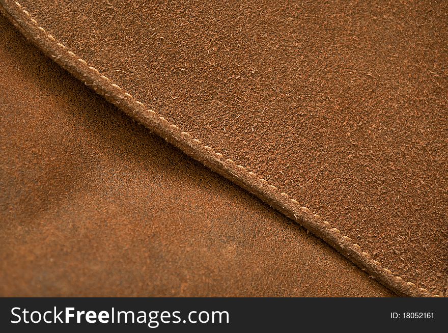 Seam on a brown pressed leather bag