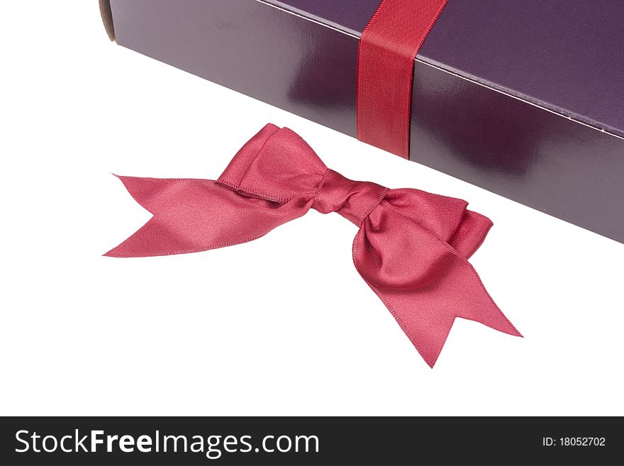 Gift box of darkly violet colour with a ribbon on a white background.