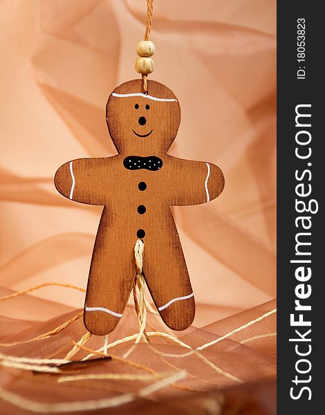 Gingerbread man of wood against a drapery background