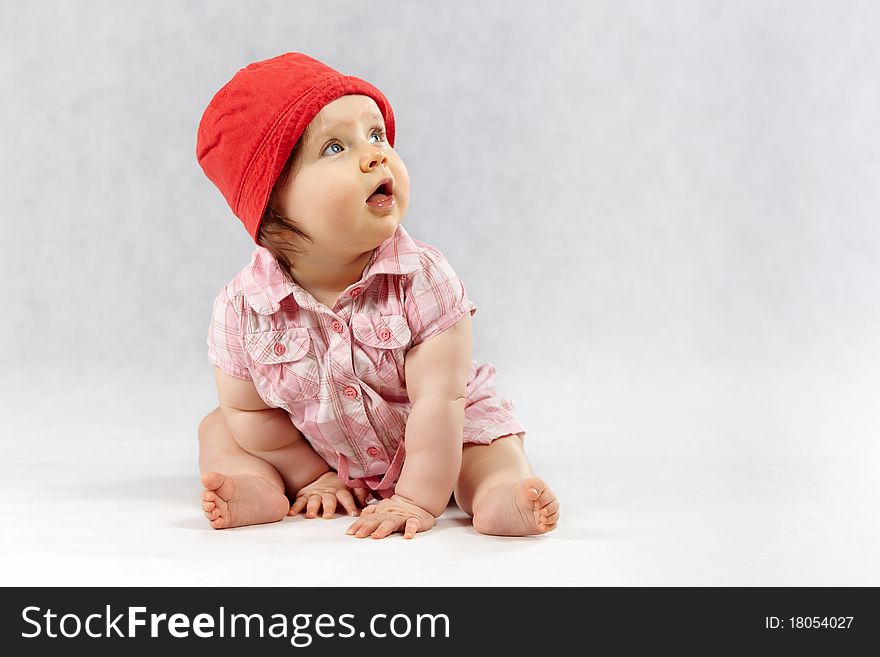 Sweet baby girl in red cap - studio shot