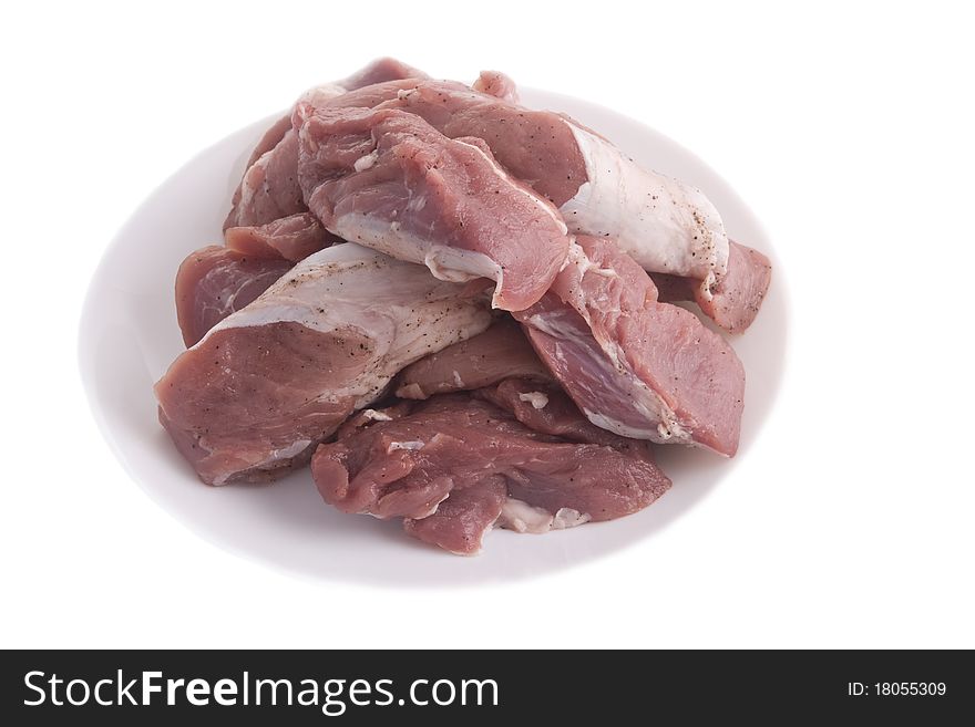 Crude meat on a plate on a white background