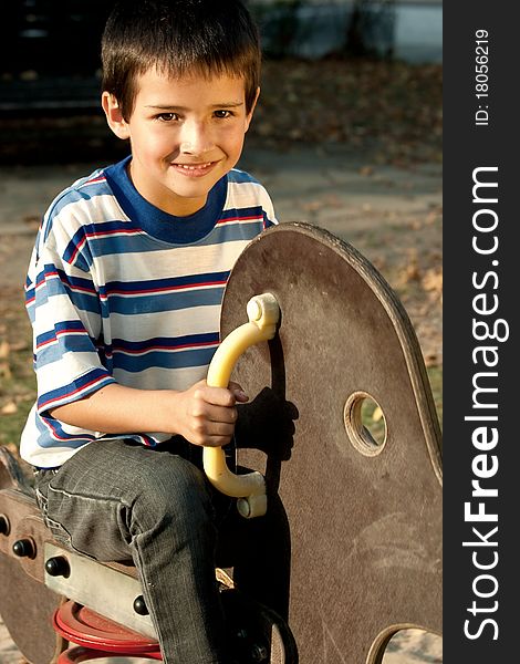 Boy on a wooden swing looking at the camera