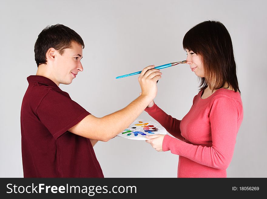Man touching nose of young girl by brush