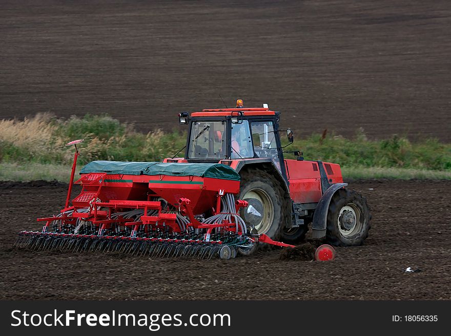 Red Tractor working on field