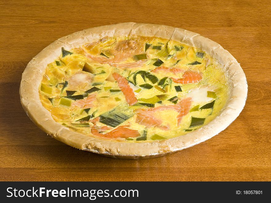Colorful baked salmon quiche on a table.