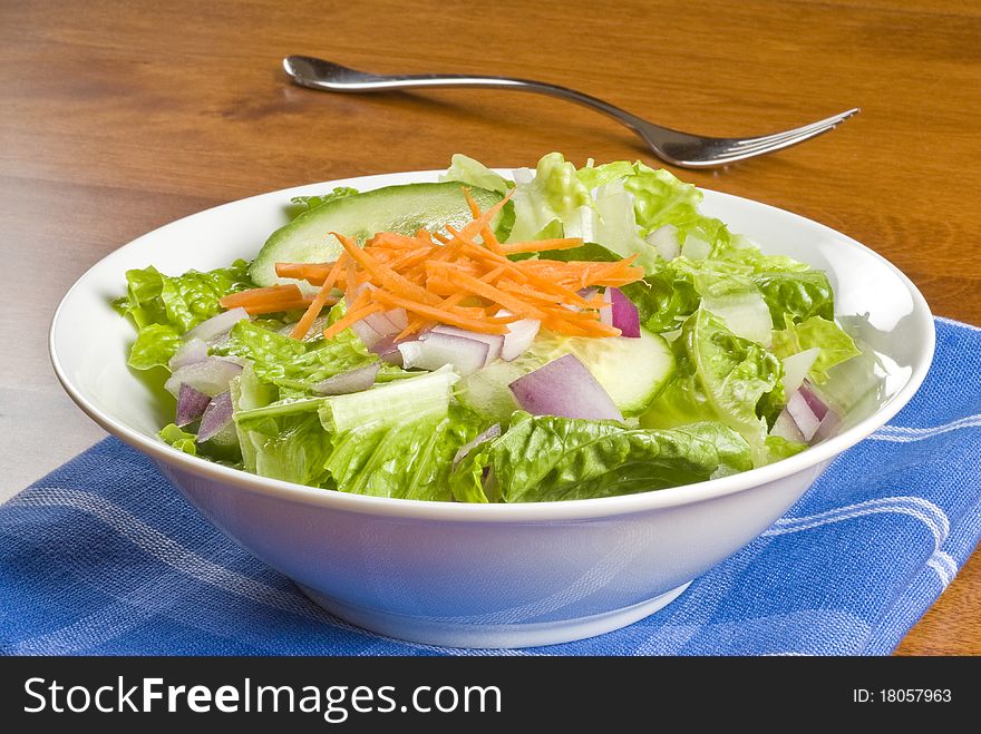 A bowl of fresh green salad on the table. A bowl of fresh green salad on the table.