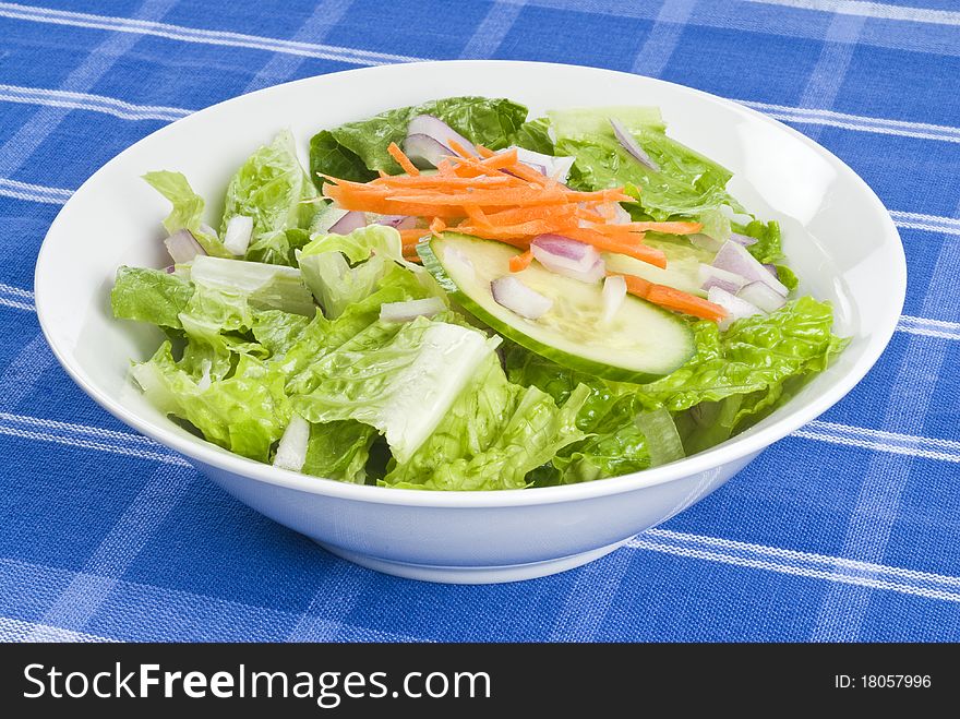 A bowl of fresh green salad on the table. A bowl of fresh green salad on the table.