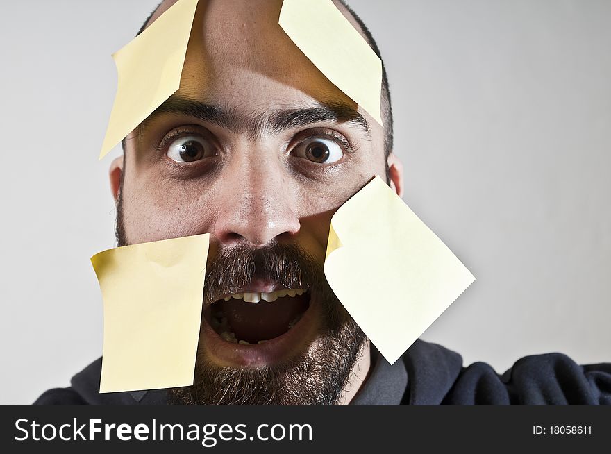 Disparate man with postit on his face on white background