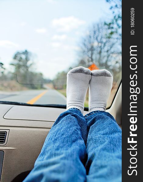 Man's feet with socks resting on dashboard while on a roadtrip. Man's feet with socks resting on dashboard while on a roadtrip.