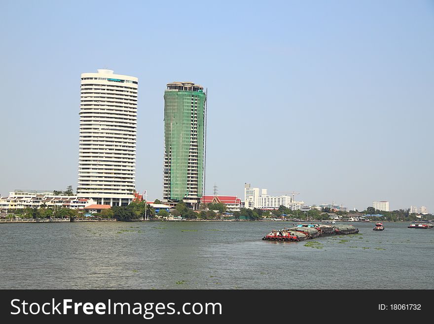 Construction and completed building on the river bank.