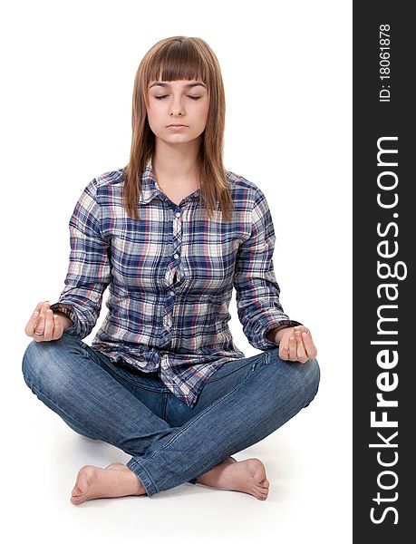 Beautiful girl in a plaid shirt sitting in the lotus position