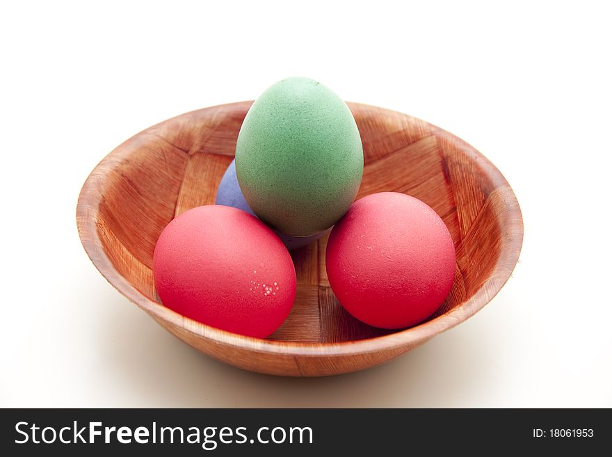 Colored eggs in the wood bowl