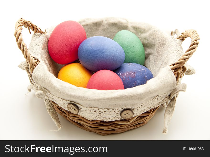 Colored eggs in the basket with material