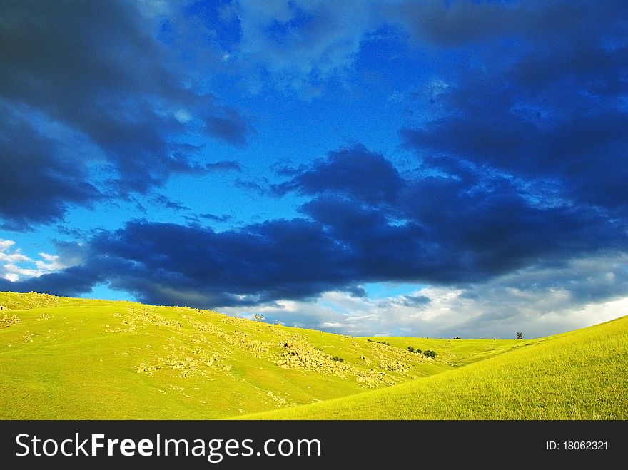 Dramatic scenery with dark clouds and sunny hills. Dramatic scenery with dark clouds and sunny hills