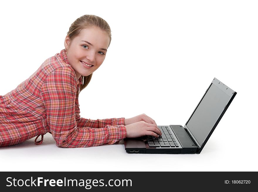 Beautiful young girl lying on the floor with laptop