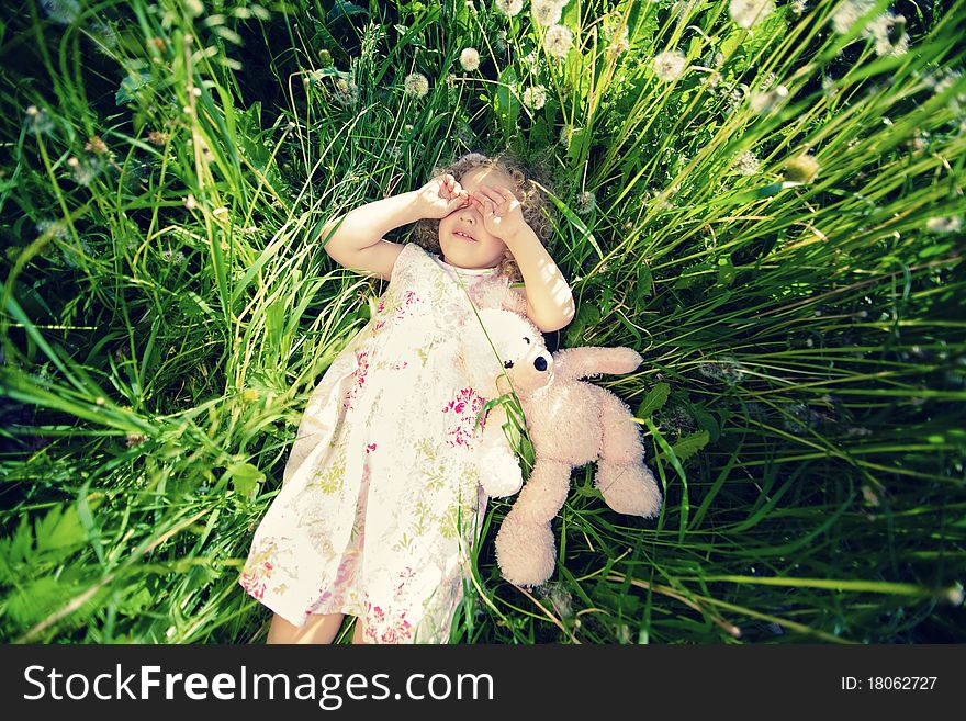 Little girl lies on back on grass. Little girl lies on back on grass