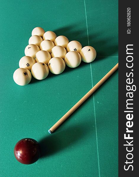 Billiards table with balls and a cue stick