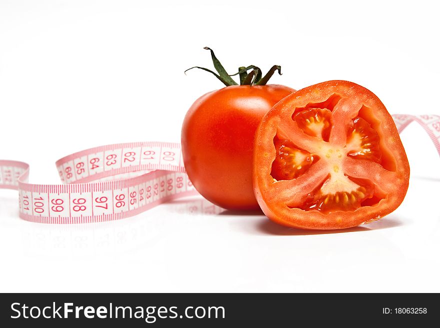 Fresh tomato and tape measure isolated ver white