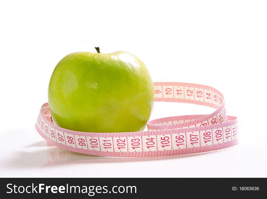 Green apple and tape measure isolated over white