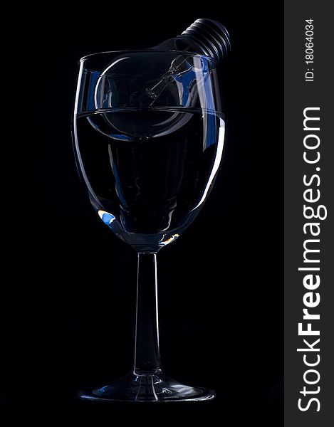 Wine glass and light bulb over black