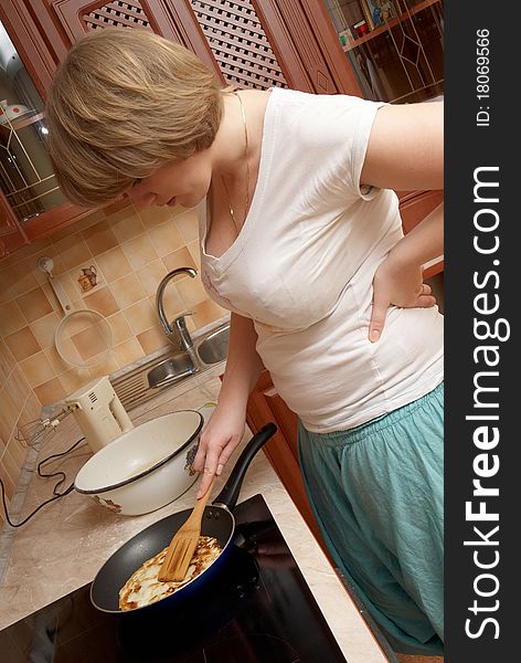A pretty plump girl preparing pancakes. A pretty plump girl preparing pancakes