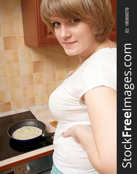 A pretty girl preparing pancakes