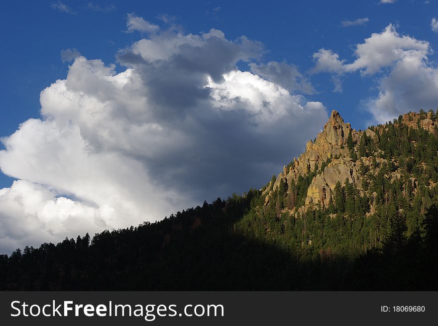 Evening in a Colorado Canyon with Crags and Cumulus clouds in foreground. Evening in a Colorado Canyon with Crags and Cumulus clouds in foreground.