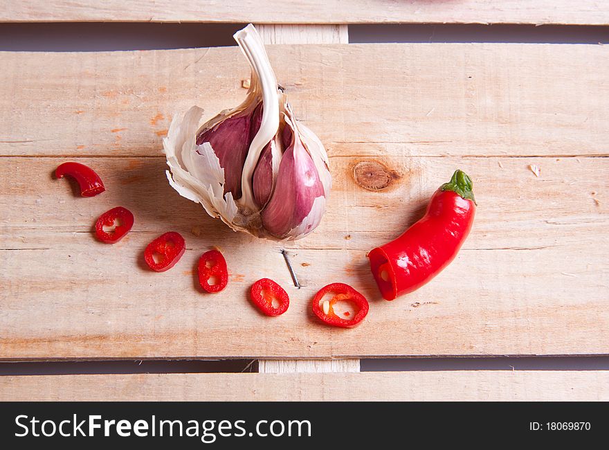 Garlic and red hot chili pepper on wooden desk. Garlic and red hot chili pepper on wooden desk