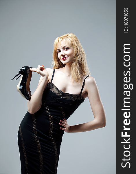 Young beautiful high blonde in a black dress with new shoes