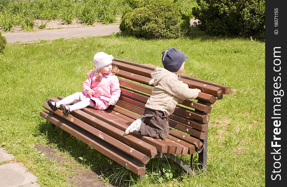 Little boy and girl in park on a bench