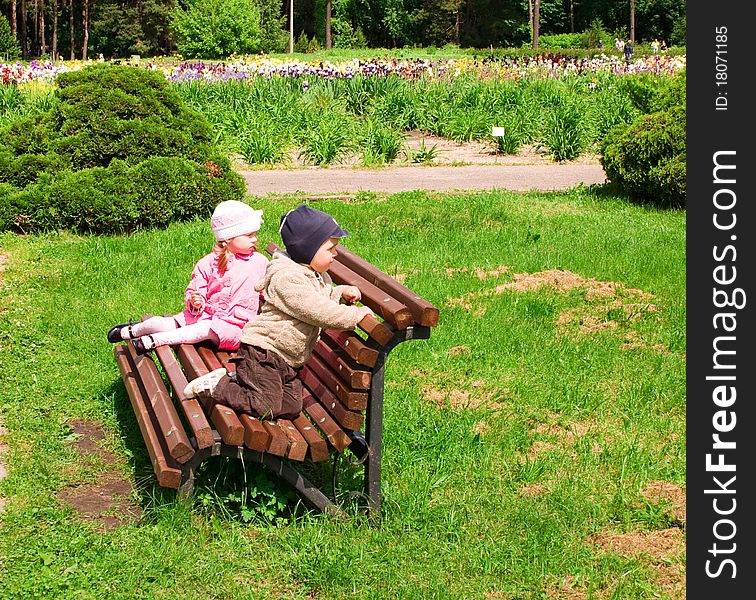 Little boy and girl in park on a bench