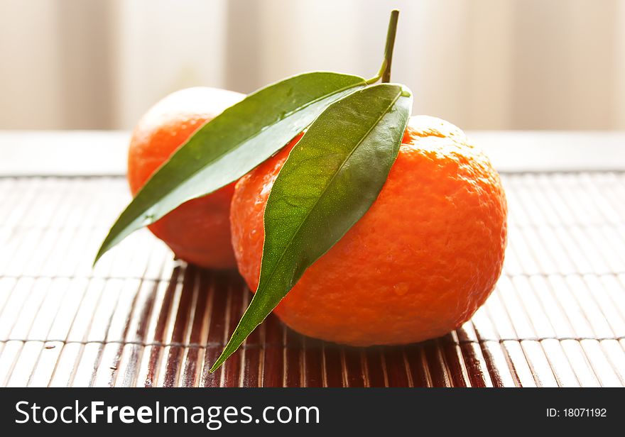Two tangerines in a straw napkin