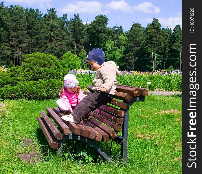 Little boy and girl in park on a bench