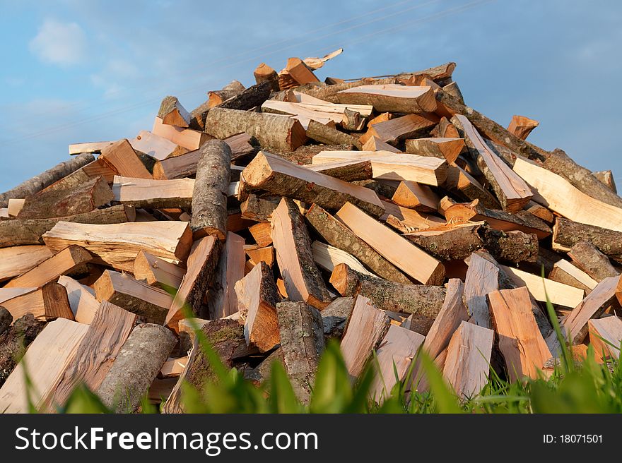 Pile of chopped fire wood on blue sky background. Pile of chopped fire wood on blue sky background