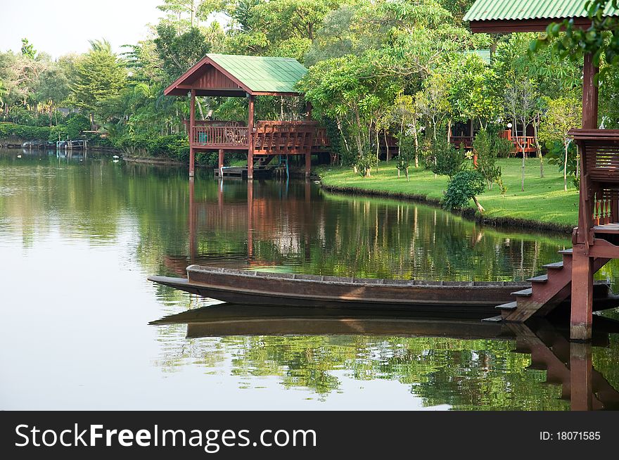 Thai boat and waterfront pavilion beside canal Thailand