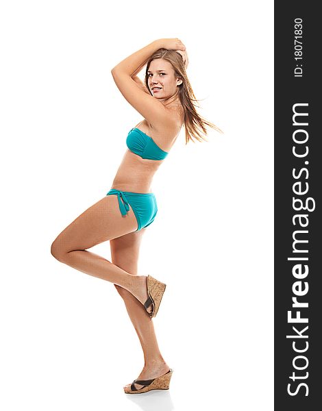 Young girl in teal bikini kicking up her knee, shot against a white background. Young girl in teal bikini kicking up her knee, shot against a white background.