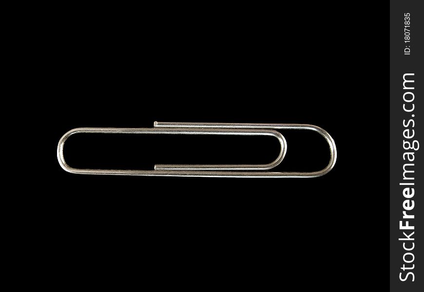 Paper clip on black, isolated macro