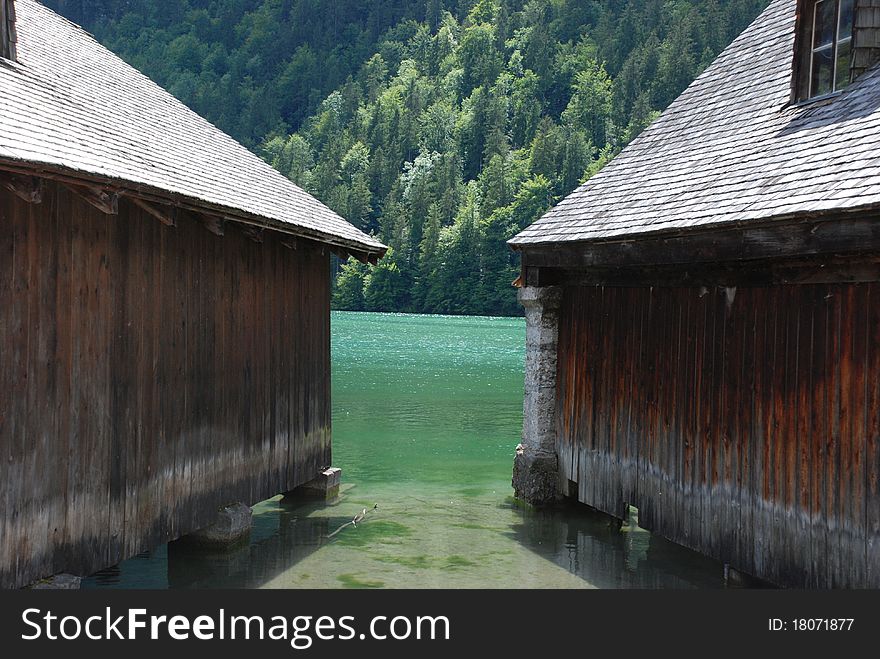 A lake with two boat garage an a forest in the background. A lake with two boat garage an a forest in the background