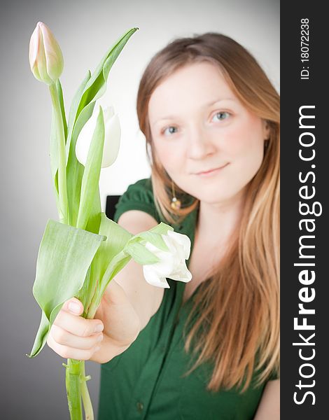 Young girl with tulips, with grey background. Young girl with tulips, with grey background