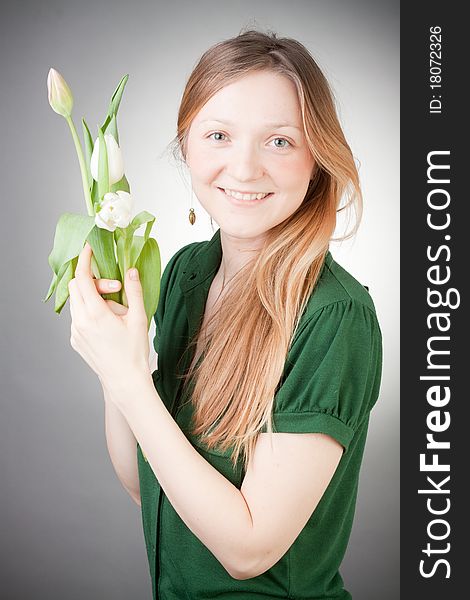 Young girl with tulips, with grey background. Young girl with tulips, with grey background